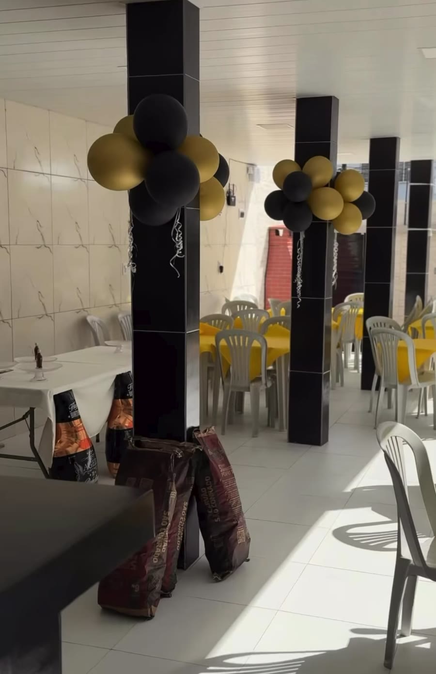 Salão decorado com balões preto e dourado